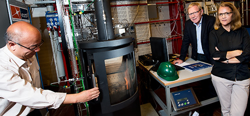 In the test hall, the stoves are fired under controlled conditions using online measurements of the most essential process parameters as well as the O2, CO, CO2, NOx, SOx gas components and volatile organic compounds in the flue gas. Particle emissions are also measured. (L – R): DTU researcher Weigang Lin, HWAM founder Vagn Hvam Pedersen, and DTU project leader Jytte Boll Illerup. (Photo: Joachim Rode.)